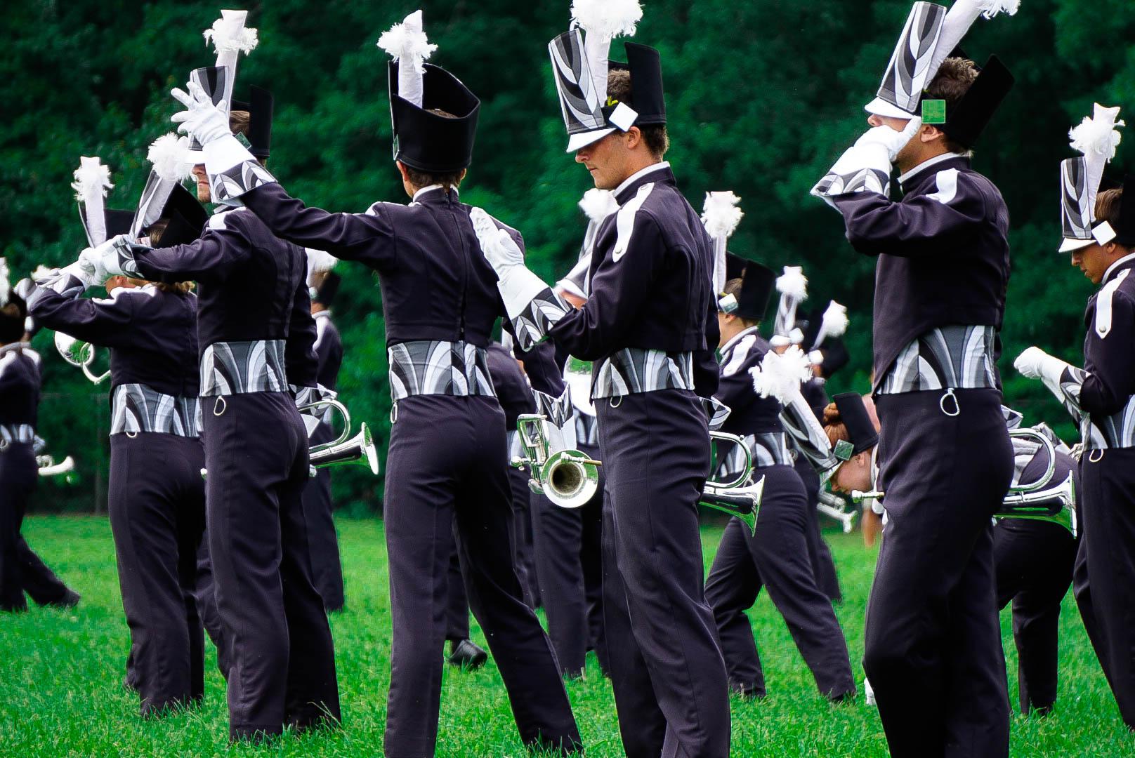 Drum corps members doing choreography during their performance.