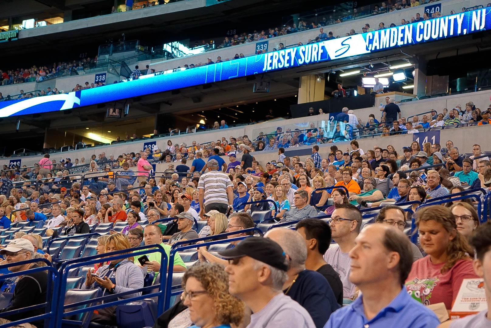 A crowd standing on their feet applauding.