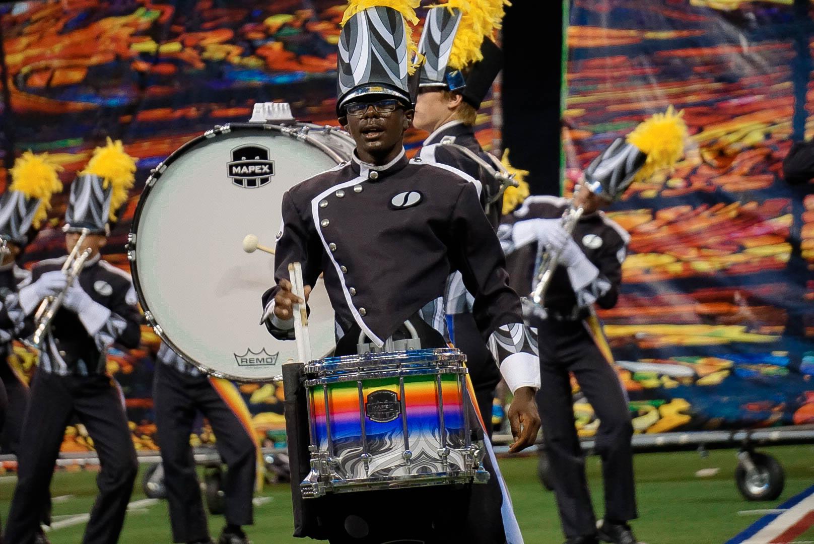 A snare drummer mid show, performing.