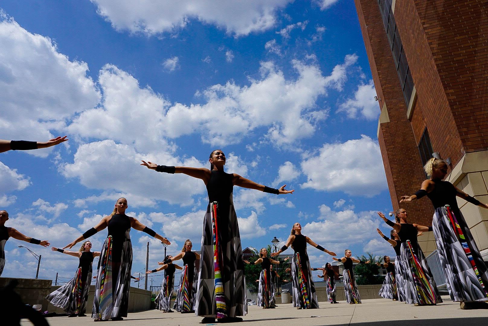 Drum corps color guard members stretching before a show.