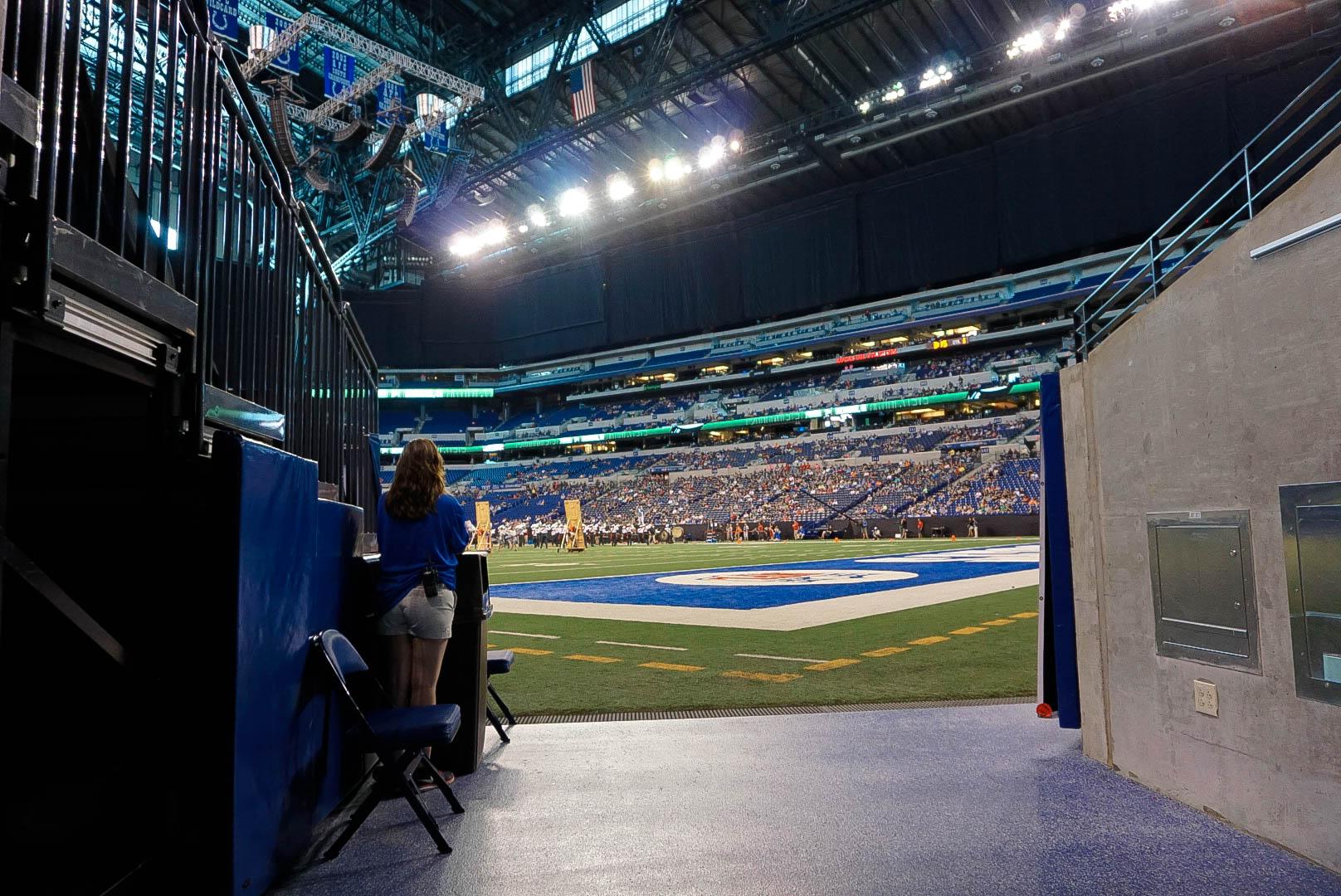 The tunnel view at Lucas Oil Stadium, displaying an empty field and a sold out crowd.